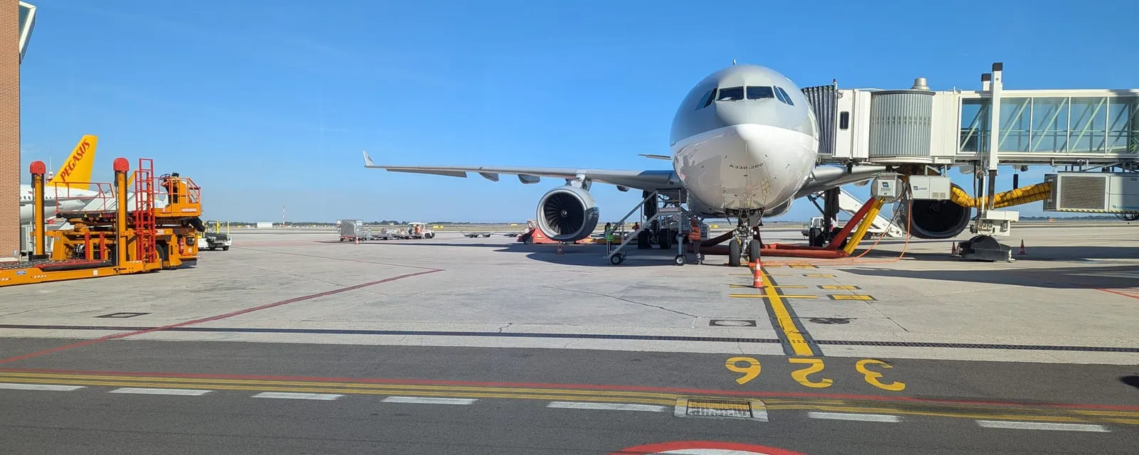 A widebody aircraft on stand with the airbridge in position, seen from the apron