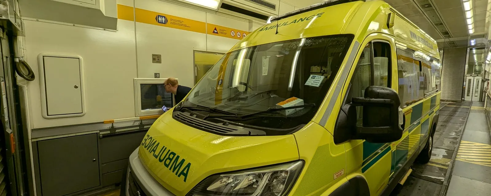 An ambulance loaded aboard a LeShuttle carriage, with crew alongside