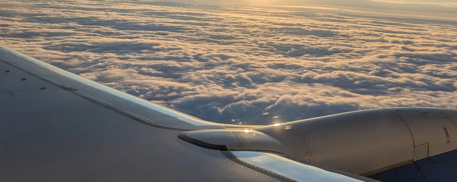 Sunrise over a cloud layer seen from the cabin of a long-haul flight